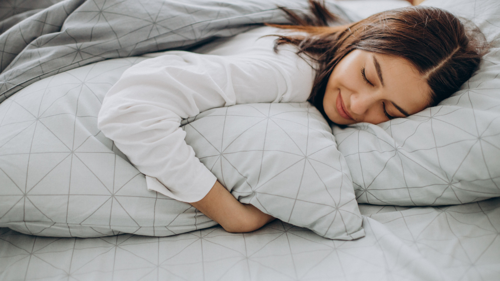 Frau schläft seitlich im Bett