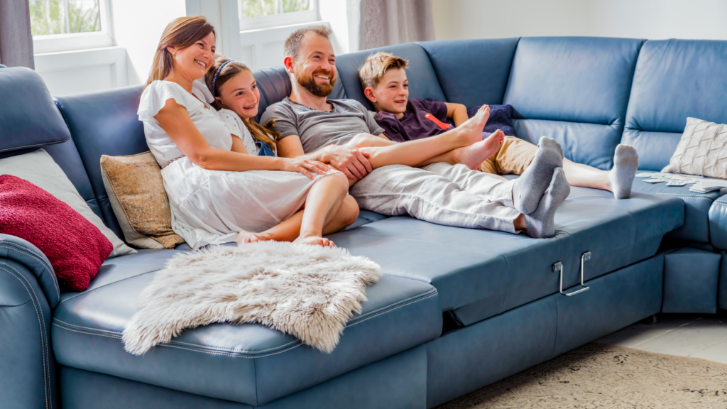 Familie sitzt auf einer Couch mit blauer Sofapolsterung